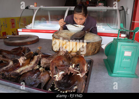 Femme mangeant la viande de chien à Guiyang, Chine Banque D'Images