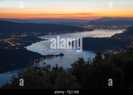 Vue du col de la Forclaz sur le Lac d'Annecy au crépuscule avec les rues illuminées et les établissements urbains, Savoie, France Banque D'Images