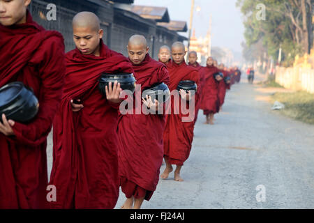 Les moines bouddhistes recevoir le riz de population, rituel quotidien, Nyaung-U, Myanmar Banque D'Images