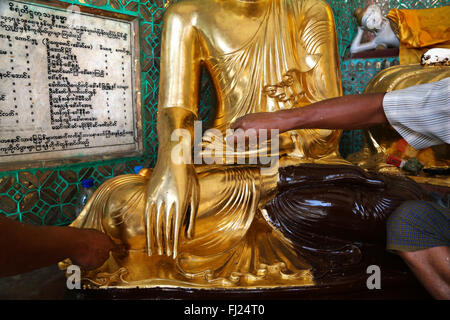 Statue de Bouddha adorant les mains en appliquant, à l'intérieur de la Pagode Shwezigon goldleaves , Rangoon Banque D'Images
