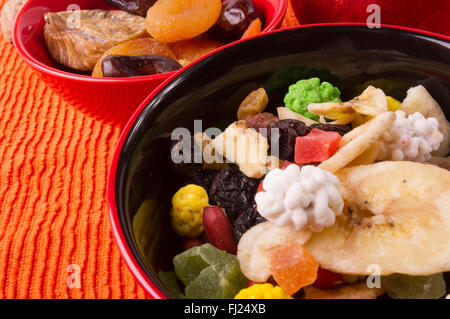 Les fruits séchés et les noix sur le fond orange textile Banque D'Images