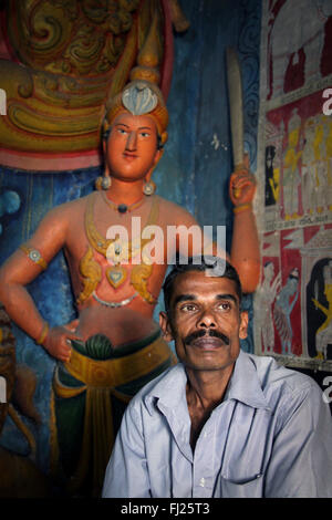 Portrait de l'homme dans un temple bouddhiste de sculptures derrière lui, au Sri Lanka Banque D'Images