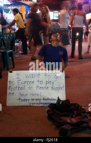 Mendiant thaï joue au football pour les touristes à Khaso San Road, Bangkok - La vie de rue à Bangkok Banque D'Images