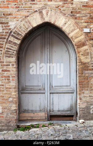 Vieille porte en bois gris avec arch dans mur de brique, la texture de fond photo Banque D'Images