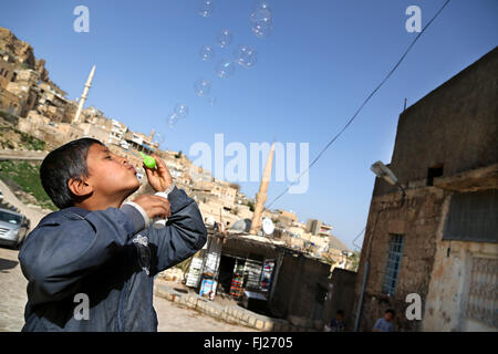 Un enfant joue avec des bulles dans la vieille ville de Mardin, Turquie orientale Banque D'Images