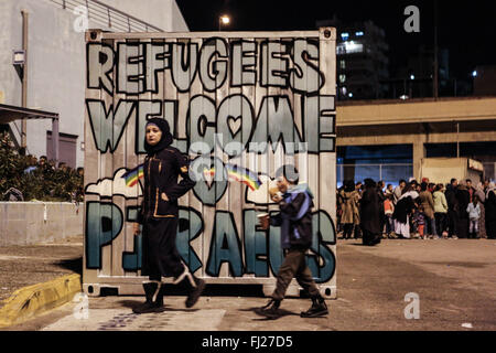 Athènes, Grèce. 28 Février, 2016. Le signe 'réfugiés Bienvenue sur le Pirée est considéré comme réfugiés dans la file d'attente avant de l'terminaux de passagers au port du Pirée en Grèce le 28 février 2016. Le bateau grec 'Adriadne' transféré quelque 1 200 personnes de la mer Égée et les îles de Lesbos, Chios, comme plus de 20 000 réfugiés qui ont débarqué de Turquie dernièrement restent bloqués en Grèce au cours de la semaine dernière grâce à l'amélioration des restrictions à la frontière sur le chemin de l'Europe centrale. Le Lefteris Crédit : Partsalis/Xinhua/Alamy Live News Banque D'Images