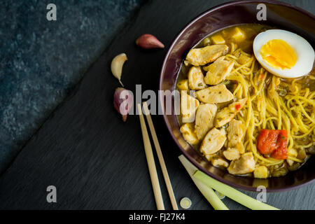 Plat d'Asie ramen, avec le poulet, les nouilles et les oeufs, vue d'en haut, sur une ardoise noire Banque D'Images