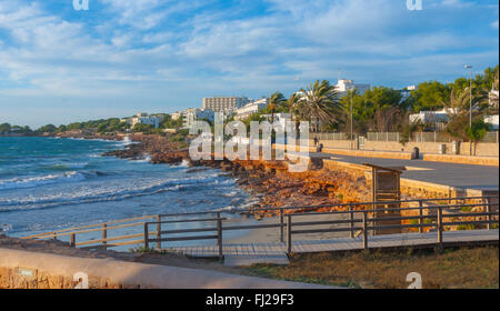 Côte d'or d'Ibiza comme vu de St Antoni de Portmany, Ibiza, Baléares le barattage de la mer de vagues sur les rochers le long du rivage que su Banque D'Images