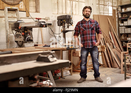 Propriétaire de l'entreprise menuiserie debout dans son atelier avec des machines Banque D'Images