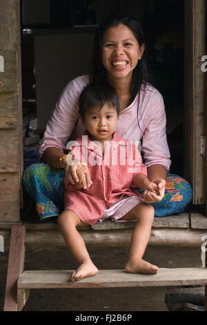 Une mère et son fils sur leur porche dans le village musulman de Tung Nang Dam situé au nord de la mer d'Andaman - Thailande Banque D'Images