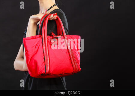 La beauté et l'élégance de la mode concept. Femme élégante Gros plan sur noir sac à main rouge holding Banque D'Images