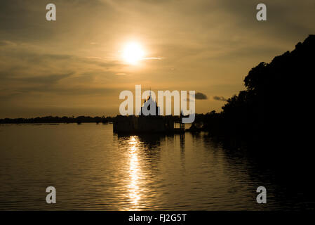 Silhouette de pagode du lac Taungthaman Mandalay Myanmar // LAC TAUNGTHAMAN, Myanmar — Une silhouette de pagode s'étend dans le lac Taungthaman près de Mandalay, l'un des plans d'eau les plus importants du centre du Myanmar sur le plan culturel. Le lac a gagné en importance pendant la dynastie Konbaung (1752-1885) quand il est devenu stratégiquement positionné entre les capitales royales changeantes du Myanmar. Situé à 11 kilomètres au sud-ouest de Mandalay dans le canton d'Amarapura, ce lac saisonnier est relié au réseau de la rivière Ayeyarwady et abrite le célèbre pont U Bein de 1,2 kilomètres. La région fonctionne comme un centre vital des Bouddhis Banque D'Images