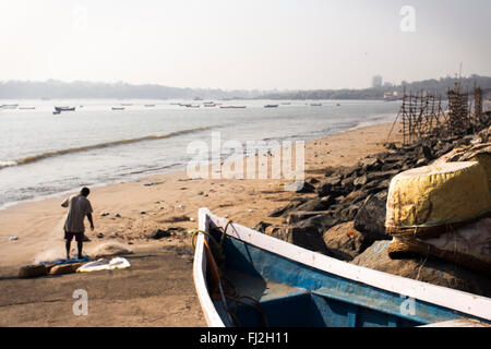 Un pêcheur recueille son filet dans la plage de Versova, Mumbai, Maharashtra, Inde Banque D'Images