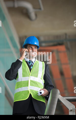 Portrait d'un Indien de sexe masculin d'un architecte ou d'ingénieur industriel à l'œuvre à l'aide de téléphone. Banque D'Images