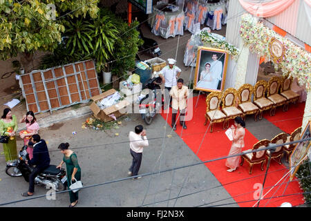 Un homme entre dans une tente avant une cérémonie de mariage dans une rue bordée d'ordures dans Kampong Cham, au Cambodge. Banque D'Images