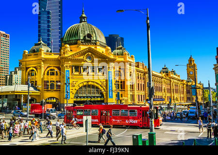 Les personnes qui traversent la rue Flinders St intersection Swanston Melbourne rouge tramway à la gare de Flinders Street Australie Banque D'Images