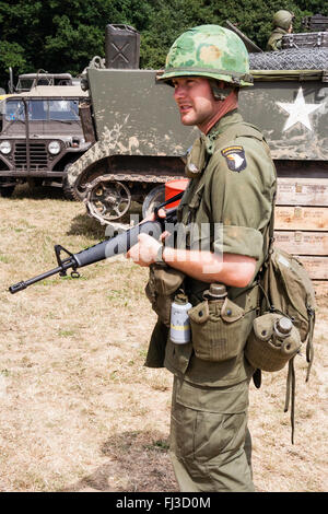 Vietnam Guerre re-enactment. Soldat américain de garde debout dans sunshine holding fusil M16, et deux cantines accrochée à la ceinture. Banque D'Images