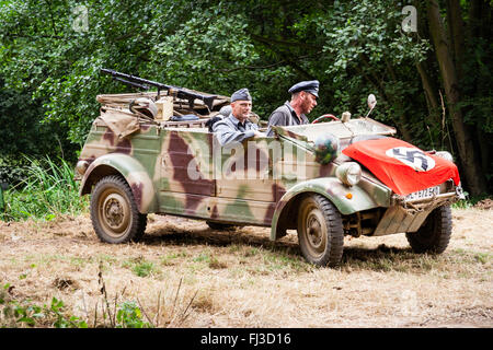 La guerre et la paix, l'Angleterre. Seconde guerre mondiale re-enactment. Kubel camouflé allemand voiture avec deux officiers et drapeau nazi drapped plus de capot, capot. Banque D'Images