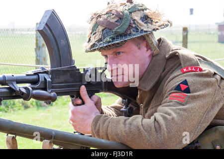 La seconde guerre mondiale remise en vigueur. La King's Shropshire Light fantassin fixant et en visant une mitrailleuse légère Bren. Portrait de face et une partie de l'arme. Banque D'Images