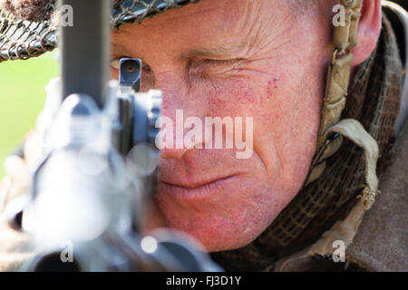 La seconde guerre mondiale remise en vigueur. La King's Shropshire Light fantassin fixant et en visant une mitrailleuse légère Bren directement au spectateur. Close up of gun et le visage. Banque D'Images