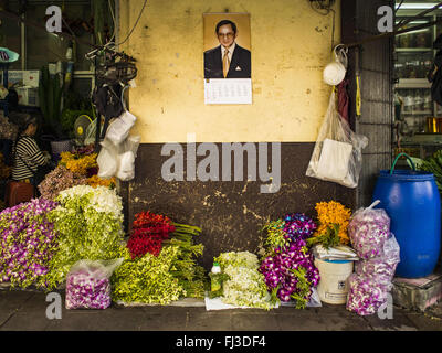 Bangkok, Bangkok, Thaïlande. Feb 29, 2016. Fleurs à vendre sur le trottoir sous un portrait de Bhumibol Adulyadej, le Roi de Thaïlande, Bangkok près du marché aux fleurs. Cette habitude d'être un grand stand de trottoir mais est maintenant juste quelques fleurs sur le trottoir. Bon nombre des vendeurs de trottoir autour de Pak Khlong Talat, le marché aux fleurs de Bangkok, fermé leurs étals lundi. Dans le cadre de l'initiative parrainée par le gouvernement militaire pour nettoyer, les représentants de la ville de Bangkok a annoncé de nouvelles règles pour le trottoir vendeurs qui réduit leurs heures et modifié le règlement qu'ils travaillaient sous. Certains vendeurs ont dit Banque D'Images