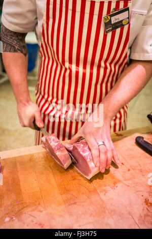 Portrait d'un boucher hacher la viande sur une planche à découper Banque D'Images