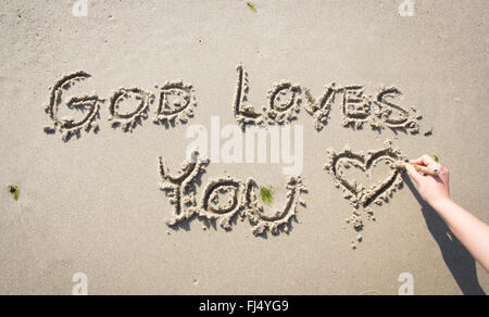 "Dieu vous aime" plage de sable dans la main Banque D'Images