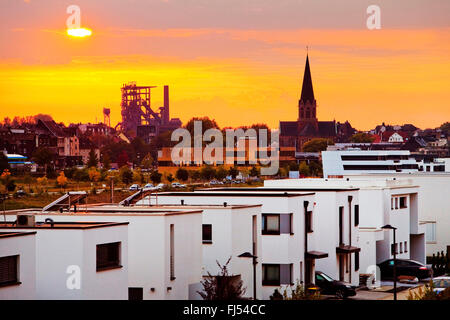 Nouveau quartier résidentiel au lac Phoenix au coucher du soleil, du haut fourneau et clocher en arrière-plan, l'Allemagne, en Rhénanie du Nord-Westphalie, Ruhr, Dortmund Banque D'Images