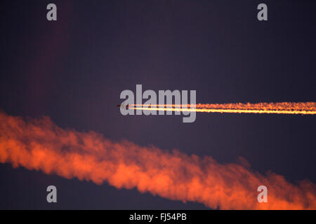 Jet avec une traînée de vapeur à l'incandescence du soir, Allemagne Banque D'Images