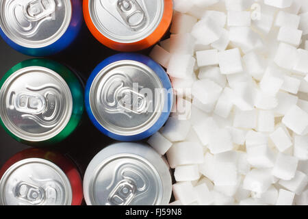 Concept d'aliments malsains - le sucre dans les boissons gazeuses. Le sucre en cubes comme arrière-plan et boire en conserve Banque D'Images