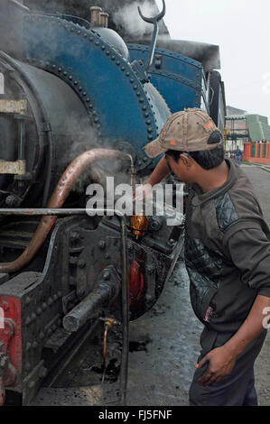 Engineer inspecting Darjeeling Himalayan Railway locomotive à vapeur de classe B 780 (DHR) 22 à la station de Ghum, dans l'ouest du Bengale, en Inde. Banque D'Images