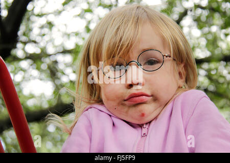 Petite fille aux taches de face donnant un haussement, portrait d'un enfant Banque D'Images