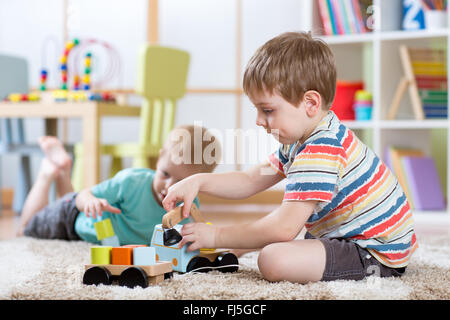 Les tout-petits les enfants garçons jouant avec petite voiture à l'intérieur Banque D'Images