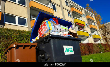 Trop plein de déchets de papier dans des conteneurs avant d'un bloc d'appartements, Allemagne Banque D'Images