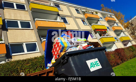 Trop plein de déchets de papier dans des conteneurs avant d'un bloc d'appartements, Allemagne Banque D'Images