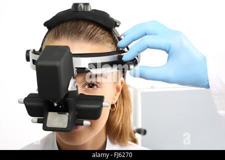 Ophtalmologiste examine les yeux à l'aide d'un appareil ophtalmique. Un examen d'oeil à un ophtalmologiste, ophthalmoscope. Banque D'Images