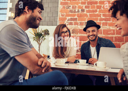 Groupe de jeunes amis dans un café. Les jeunes hommes et de femmes réunis dans un café d'avoir du plaisir. Banque D'Images