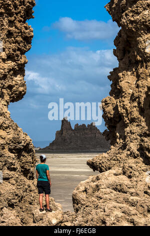 Femme debout par des formations rocheuses Lac abbé, Djibouti, Afrique Banque D'Images
