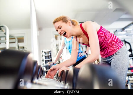 Détail de women in gym rire, rangée d'haltères Banque D'Images