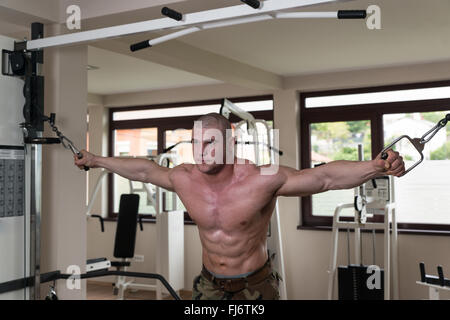 Bodybuilder travaille sur sa poitrine avec Cable Crossover In Gym Banque D'Images