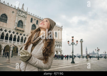 Venise, Italie charmant peut aider à tirer le meilleur parti de votre prochaine escapade d'hiver. Happy young woman sightseeing sur la Place Saint Marc Banque D'Images