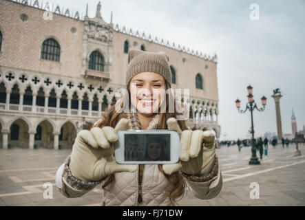 Venise, Italie charmant peut aider à tirer le meilleur parti de votre prochaine escapade d'hiver. Happy young woman with mobile selfies en tourisme Banque D'Images