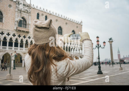 Venise, Italie charmant peut aider à tirer le meilleur parti de votre prochaine escapade d'hiver. Vus de derrière, jeune femme Prise de photos touristiques Banque D'Images