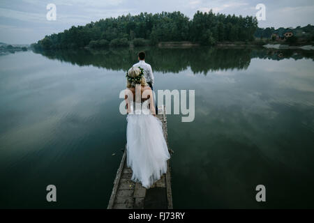 Couple de mariés sur la vieille jetée en bois Banque D'Images