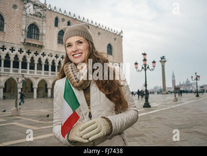 Venise, Italie charmant peut aider à tirer le meilleur parti de votre prochaine escapade d'hiver. Happy young woman tourist avec drapeau italien standin Banque D'Images