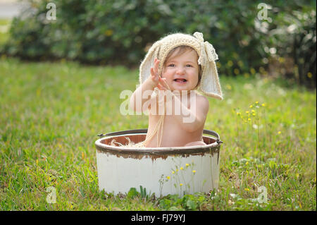 Une petite fille souriante portant un bonnet de lapin, en bonneterie. Banque D'Images