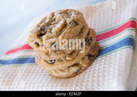 Pile de cookies aux pépites de chocolat fait maison sur rouge, blanc et tissu bleu Banque D'Images