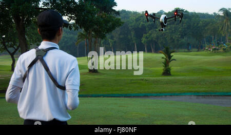 Les hommes asiatiques aux commandes d'un drone dans un parc Banque D'Images