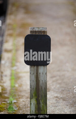 Blank sign de matériel sur un tableau noir en bois monté sur un trottoir. Banque D'Images