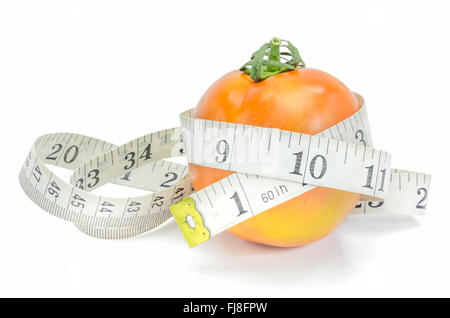 Vivre en santé - la tomate fraîche avec ruban à mesurer sur fond blanc. Banque D'Images